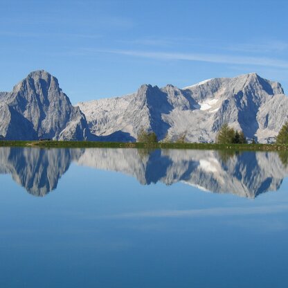 Traumhafter Anblick der Berge inklusive Spiegelbild im See. 