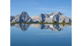 Traumhafter Anblick der Berge inklusive Spiegelbild im See. 