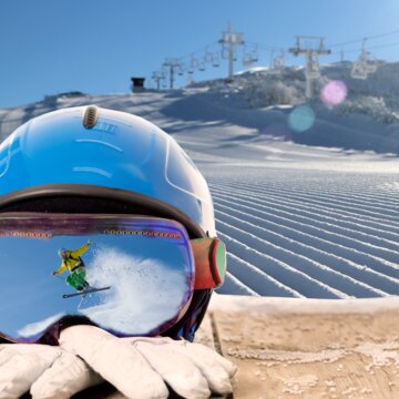 Gipfellift Stillleben  mit Skiausrüstung und Spiegelung in der Skibrille | © Bergbahnen Kössen