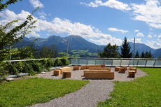 A cosy seating area made of wood invites guests on Wurbauerkogel to have a seat. 