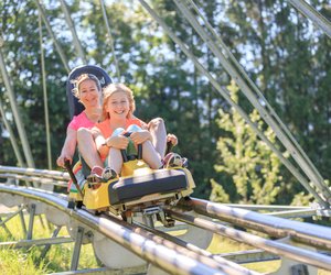 A mother and daughter on a two-person sled on the Alpine Coaster.  | © Hinterramskogler