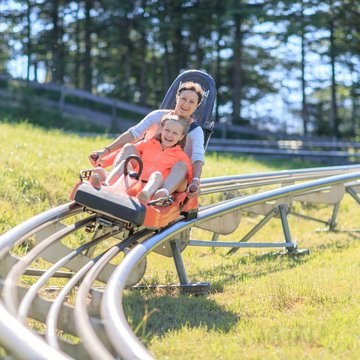 A mother and daughter enjoying the speedy ride with the Alpine Coaster on Wurbauerkogel.  | © Hinterramskogler
